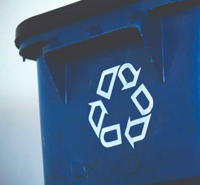 A blue bin with the recycling symbol