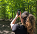 A woman takes a photo at Summit Woods