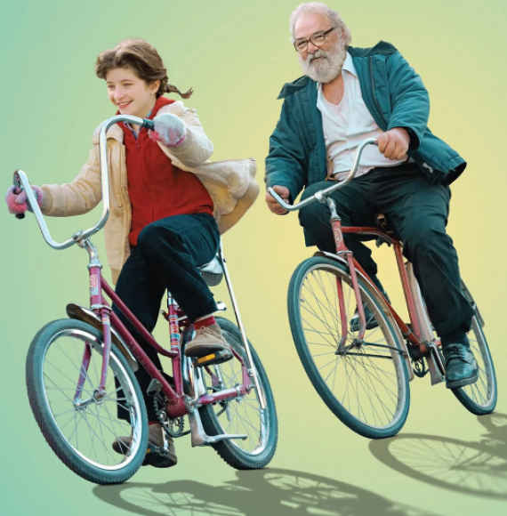Une jeune fille et un homme plus âgé, barbu, roulent à vélo vintage.