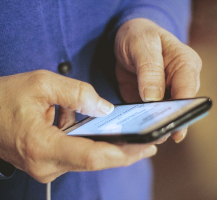 Un téléphone intéligent entre les mains d'une personne plus âgée