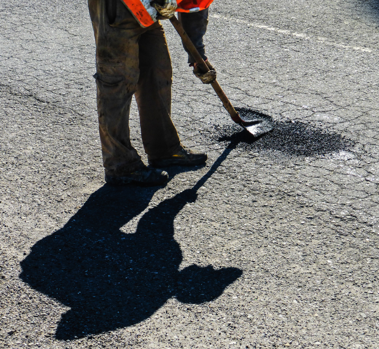 A worker fills a pothole
